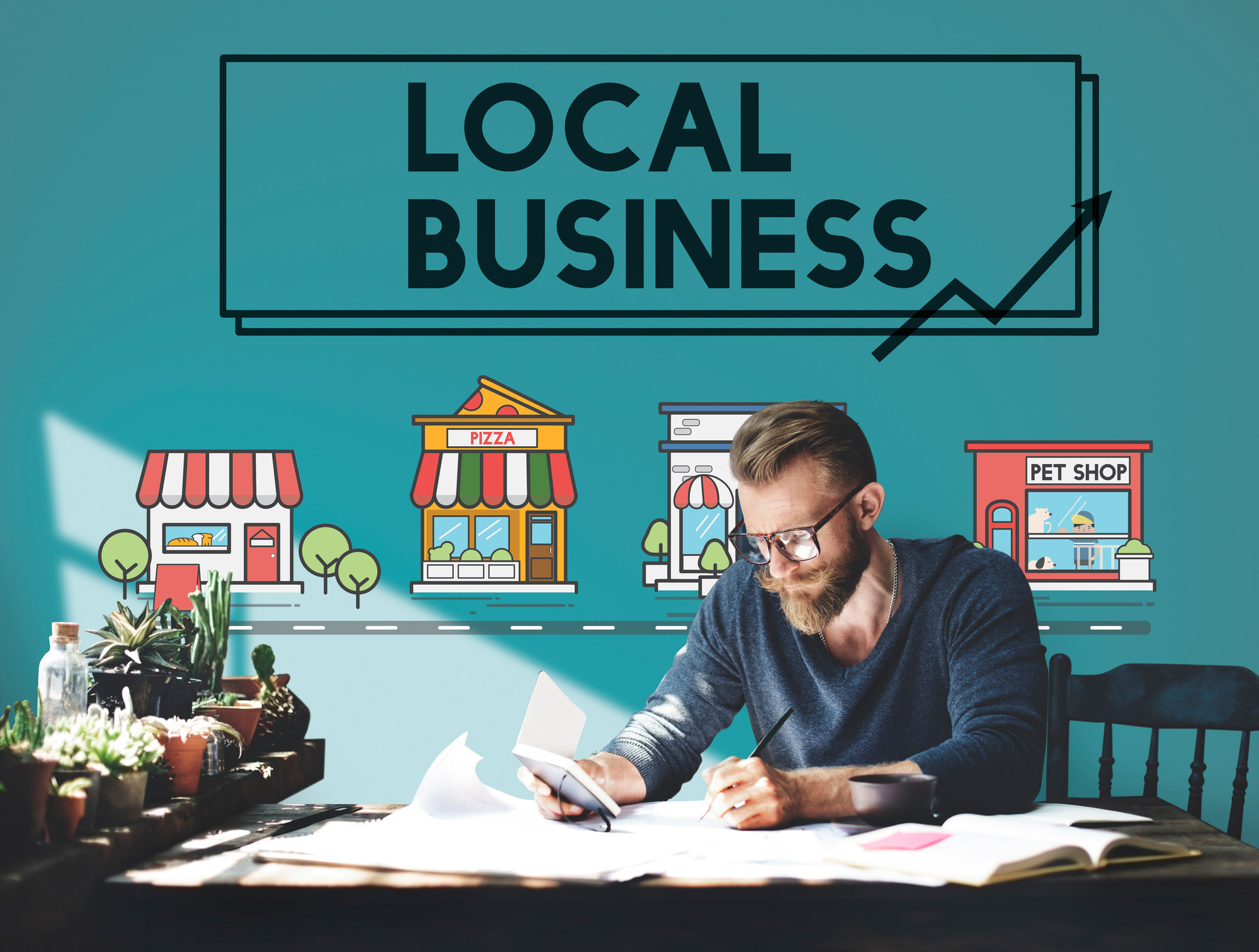 Man sitting under a banner which says local business at a desk.